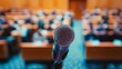 © decorator - Anticipation builds  blurred microphone in lecture hall captures audience excitement for speech