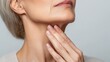 © Rodica - Mature caucasian female examining neck skin, close-up view on aging. Facial Fillers and Cosmetic Injections. Anti-wrinkle injections, Botox and fillers. Menopause Skin Care