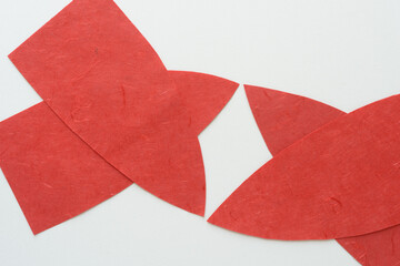 Wall Mural - abstract shapes composed of two overlapping pointy shaped red paper forms on blank paper