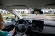 © fotodrobik - A woman confidently driving a modern car equipped with a hightech dashboard interface
