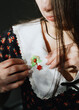 © Nataliya - The brunette girl attached a martisor to the collar of her dress.