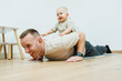 © DSMT - Playful bonding moments A father and his baby enjoy a fun workout, strengthening their connection