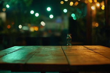 Wall Mural - Empty wooden table at night with bokeh lights in the background.