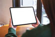 © Farknot Architect - Mockup image of a woman holding digital tablet with blank desktop screen in cafe