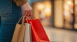 © KeetaKawee - Young Person Holding Colorful Shopping Bags While Walking Through a Bright Retail Store Aisle with Blurred Background of Storefronts