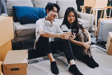 Wall Mural - Smiling couple unpacking boxes in new house