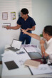 © Pichsakul - A group of engineers reviewing structural designs and material specifications at a meeting table
