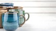 © Biggy - Colorful ceramic mugs arranged on white wooden background