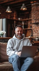Poster - Middle-aged man working on laptop in cozy cafe with rustic decor during daytime