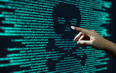 Wall Mural - human hand points at abstract modern tech of programming code screen with skull. computer virus, mal