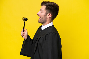 Wall Mural - Judge caucasian man isolated on yellow background laughing in lateral position