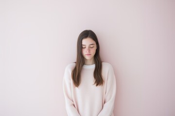 Wall Mural - A woman is wearing a pink sweater and looking at the camera