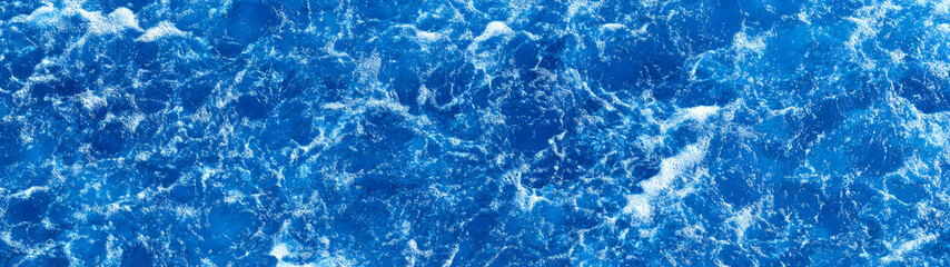Poster - Stunning image of powerful and dynamic blue ocean waves crashing into the coastal shoreline creating a dramatic display of foamy splashes and turbulent water movement