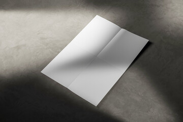 Wall Mural - blank folded paper sheet lying on a concrete floor with dramatic lighting and shadows. 3d rendering