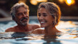 © Point of view - middle aged couple man and woman laughing in hot spring, pensioners relaxing in spa center , senior couple in a swimming hot pool