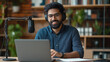 © Maksym - A young Indian entrepreneur leading an online seminar, animatedly explaining strategies with a headset on, while a microphone and webcam capture his lecture. His stylish office set