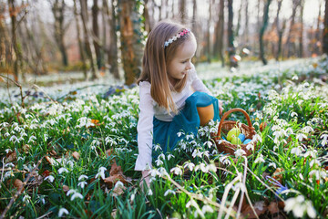 Wall Mural - Five year old girl playing egg hunt on Easter