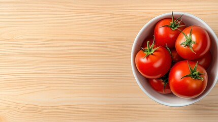 Wall Mural - Overhead shot of ripe red tomatoes in a white bowl on a light brown wooden surface. Plenty of copy space