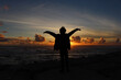 © Sara - Young man with arms outstretched, enjoying a breathtaking sunset over the ocean, capturing a moment of freedom and tranquility.