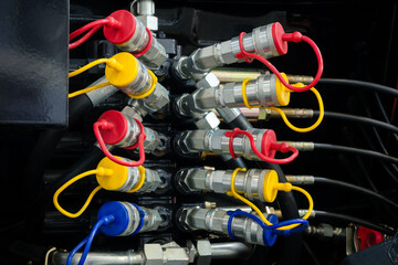 Aufkleber - A close-up of a bundle of pipes and wires of an industrial hydraulic machine. The concept is of complexity and technicality, as the various components are intricately connected and interdependent.