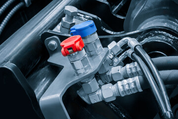 Aufkleber - A close up of a car engine with a blue and red cap on a hose. The hose is connected to a black hose  industrial concept background