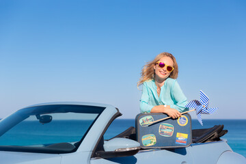 Wall Mural - Happy young woman with retro suitcase travel by car by the sea