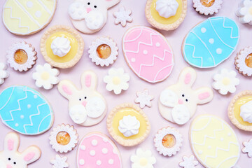 Aufkleber - Easter or spring themed baking background with assorted cookies and sweet desserts. Overhead view on a pink stone background.