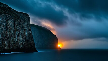 Wall Mural - sunset over rocky cliffs with dramatic clouds in coastal landscape during twilight hours