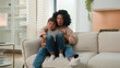 © Yuliia - Multiracial upset sad family African American woman mom mother babysitter cuddling hugging little son boy child kid on sofa couch in living room relax rest together hug embrace cuddle casual weekend