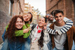 © Jose Calsina - Diverse group of happy high school students posing outdoors, smiling and enjoying time together, showcasing friendship, youth and positivity. Teenage people giving a piggyback ride to their classmates