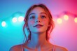 © nik_yurginson - Young actress confidently presenting in a vibrant setting with colorful lights