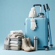 © organik - A suitcase filled with winter gear and skis against a blue background.