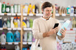 © JackF - Adult man buyer scanning qr code for shampoo or shower gel in household chemicals store