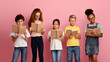 © Prostock-studio - Diligent pupils of different races reading books together on pink background
