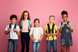 © Prostock-studio - Back to school again. Joyful children with backpacks standing together on pink background