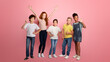 © Prostock-studio - Full length portrait of happy diverse schoolkids making different gestures over pink background