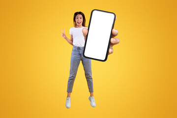 Wall Mural - wow. emotional overjoyed young woman with excited funny facial expression holding big empty cell pho