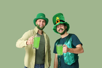 Wall Mural - Happy young men in leprechaun hats with green beards holding glasses of beer on green background. St. Patrick's Day celebration