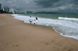 © alexkoral - back of happy family with a child son running along the beach by the sea in summer