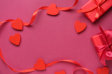 Wall Mural - Frame made of ribbon with red hearts and gift boxes on pink background. Valentine's Day celebration