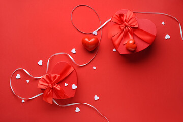 Wall Mural - Gift boxes with ribbon and hearts on red background. Valentine's Day celebration