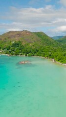 Wall Mural - A sweeping curved coastline with green hills, a tranquil turquoise bay, and soft white sands. Praslin, Seychelles.