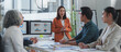 © crizzystudio - Asian businesswoman leading a meeting, presenting marketing data analysis displayed on computer screens to her colleagues, working together in modern office