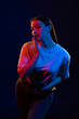© Tatiana - Young girl posing and moving in a black studio with colored light