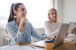 © Westend61 - Happy young businesswoman with hand on chin sitting at office meeting