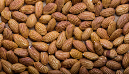 Fototapete - Repeating pattern of raw or roasted almonds, emphasizing their textured surface and warm beige tones. Ideal for healthy snacks, baking, or natural food concepts. Texture, background.