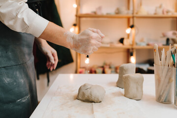 Poster - Female potter rolls piece of clay before sculpting. Preparing clay for making ceramic crockery.