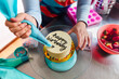 © Westend61 - Young woman piping happy birthday using icing bag on cake