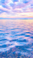 Wall Mural - serene ocean reflecting colorful sunset sky. coastal beauty for calming background