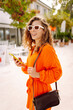 © maxbelchenko - Happy woman tourist walking on city street using smartphone.  Lifestyle, travel, tourism, technology, blogging, communication concept